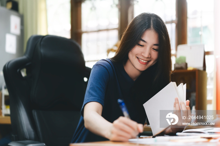 Young adult freelancer asian woman write work in office at home