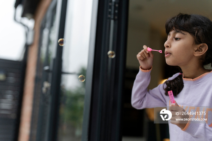 Little girls blowing soap bubbles outdoors