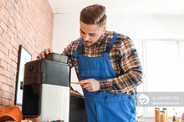 Man repairing coffee machine in kitchen