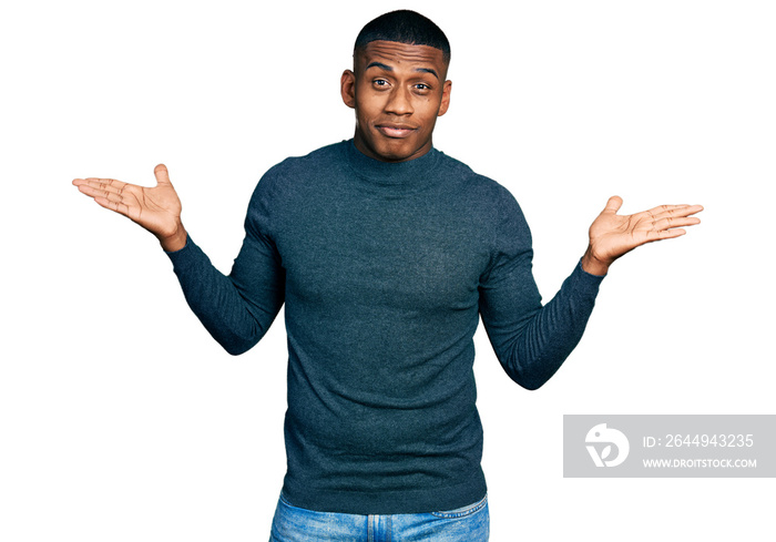 Young black man wearing casual sweater clueless and confused with open arms, no idea and doubtful face.