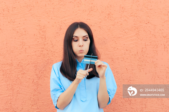 Woman Cutting Credit Card in Half with Scissors