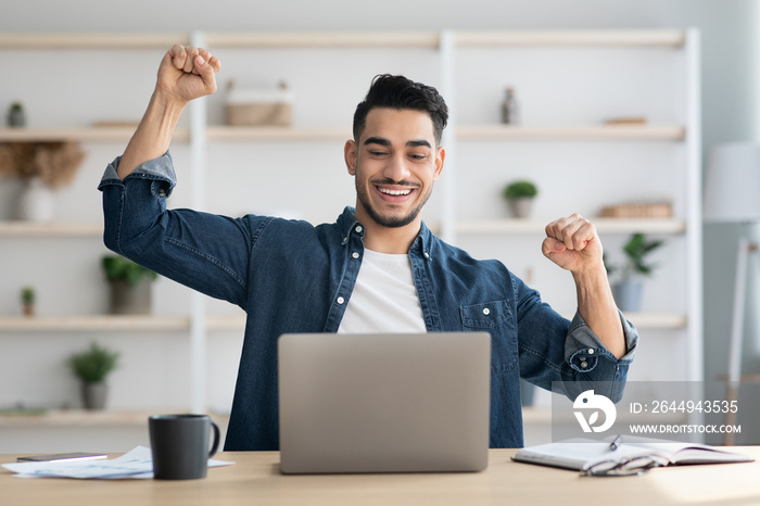 Emotional arab man freelancer celebrating successful business deal