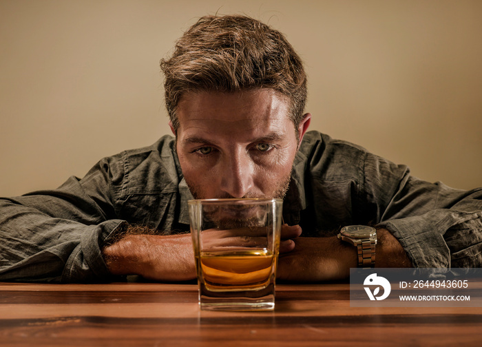 desperate alcoholic man . depressed addict isolated in front of whiskey glass trying not drinking in dramatic expression suffering alcoholism and alcohol addiction problem