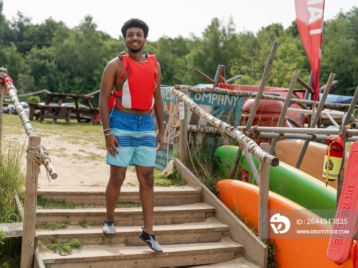 Young man walking on beach before paddleboarding