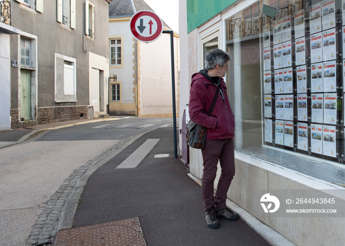 A man looks at a shop window to choose something