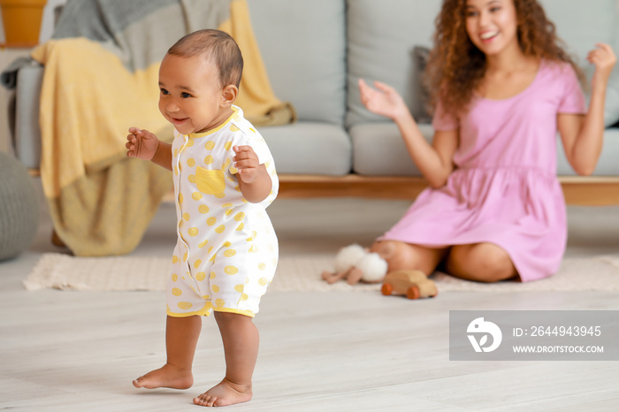 Cute little baby learning to walk at home