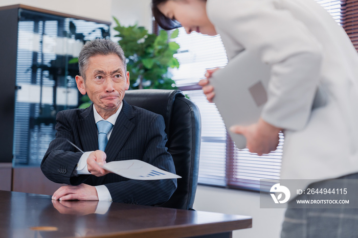 書類を突き返す会社役員の男性