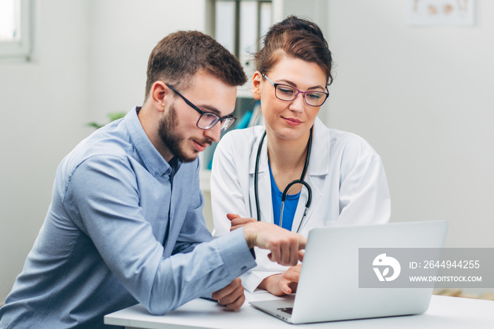 Doctor and Intern Looking at Test Results on Laptop Close Up