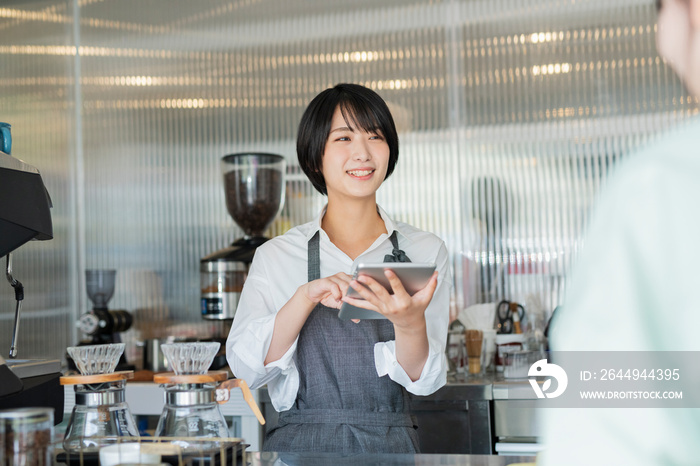 カフェ 注文をとる女性スタッフ