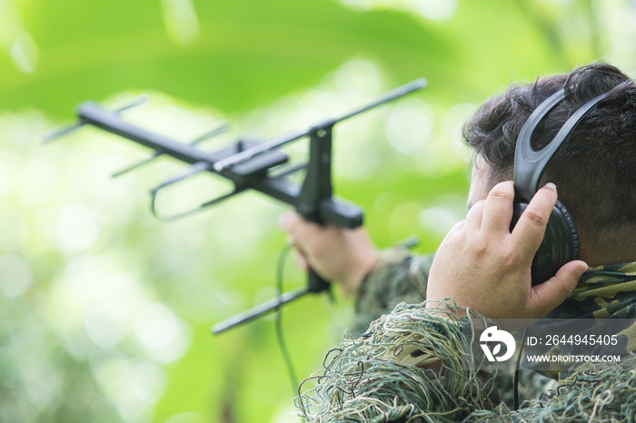 rnithologist take antenna and earphone for tracking animal movement in forest for research