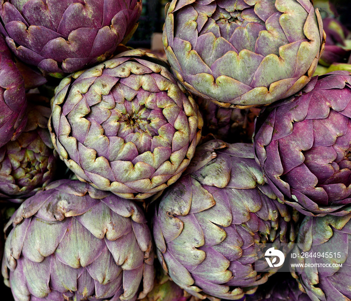 grande quantità di carciofi in primo piano fotografati al mercato