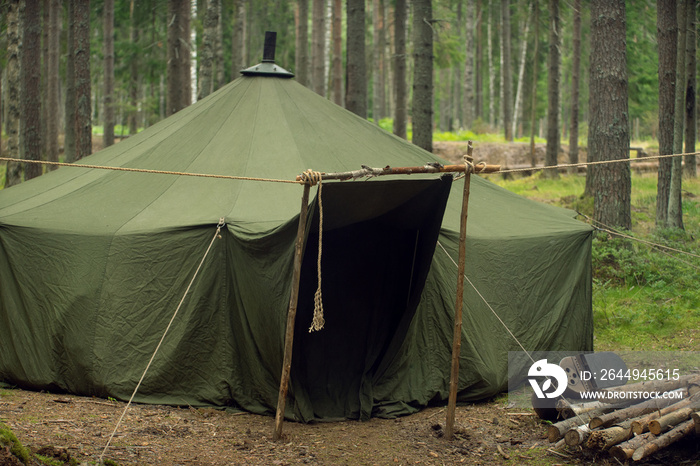 A military field tent in the forest. Soldiers in the forest at a halt. Forest ambush. Military life.