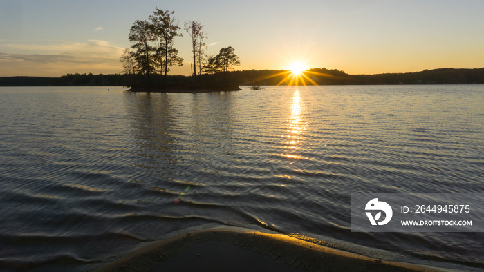 A scenic view of a sunset over a lake.