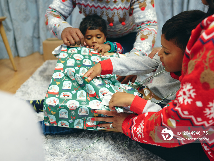 Family with sons opening Christmas presents