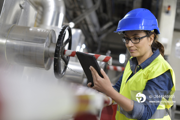 Industrial technician connected with tablet in recyling plant