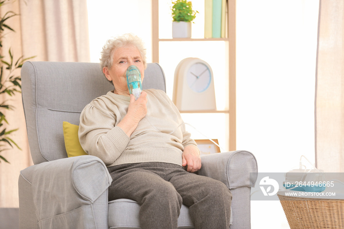 Elderly woman using asthma machine at home