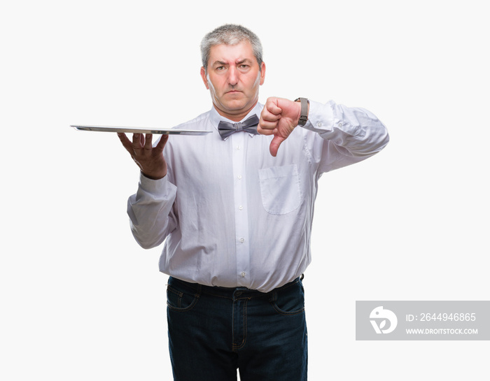 Handsome senior waiter man holding silver tray over isolated background with angry face, negative sign showing dislike with thumbs down, rejection concept