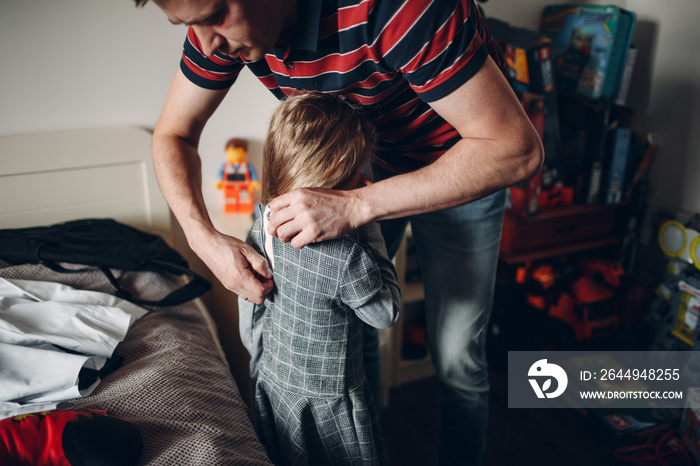 Father helping daughter dressing uniform preparation back to school