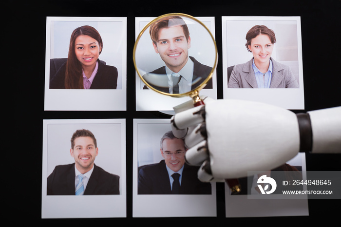 Robot Looking At Candidate Photograph With Magnifying Glass