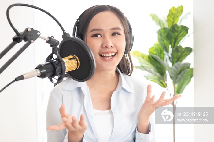 Beautiful asian young woman radio host working in headphones, microphone while talk, conversation and recording podcast, live on social media.Technology of on-air online in broadcasting at studio.