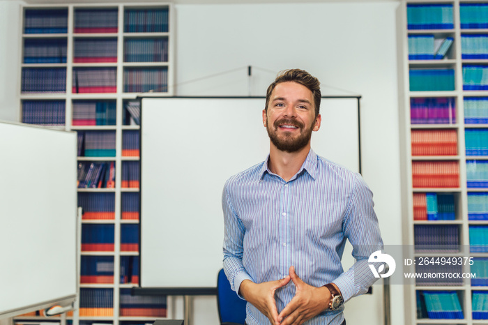 Smiling male coach giving presentation for audience in lecture hall