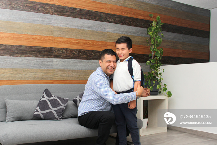 Latin dad with his overweight son prepare for back to school with uniform, and backpack show their love in the living room