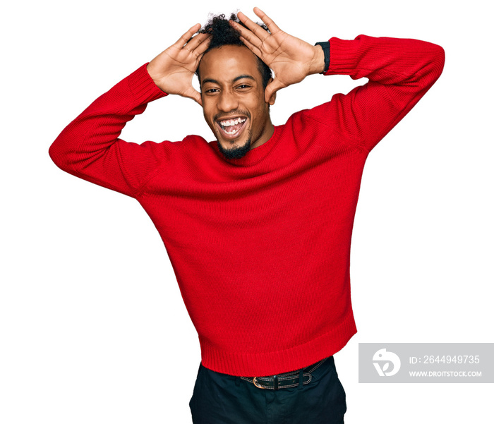 Young african american man with beard wearing casual winter sweater smiling cheerful playing peek a boo with hands showing face. surprised and exited