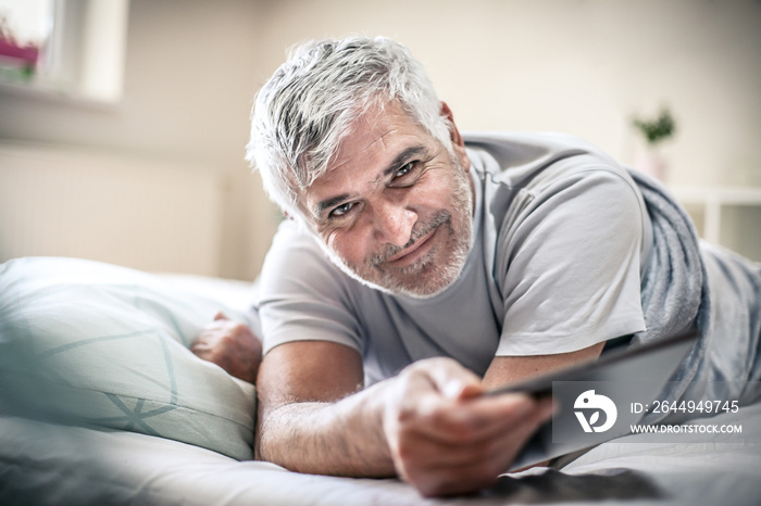 Smiling senior man in bed.