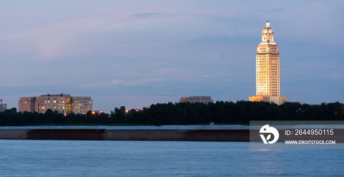 Night Falls While a Barge Travels Down Mississippi River Showing State Capital Building Baton Rouge