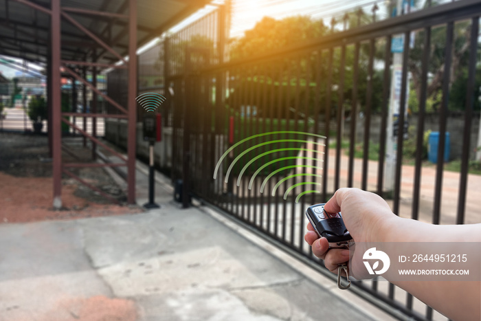 Signal of remote control when person open automatic gate at house for home security system with sunlight rays