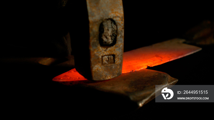 MACRO, DOF: Stunning shot of hot piece of metal held by tongs and hit by hammer