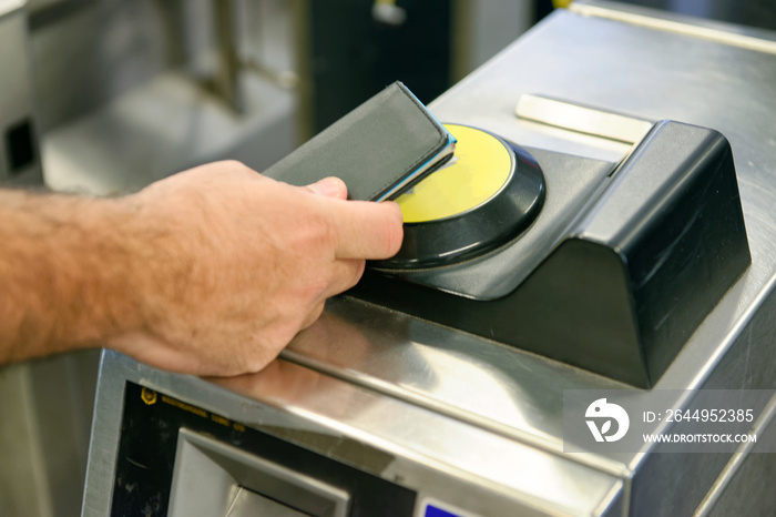 Man hand using card to enter city subway gate