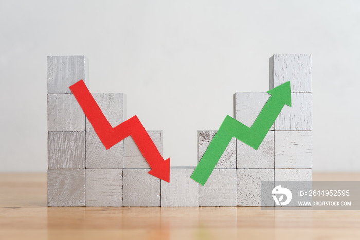 Wood bar chart and arrow red green graph chart volatility up and down on wooden table white wall background. Business, financial and investment concept. Risk, fluctuation in stock market and crypto