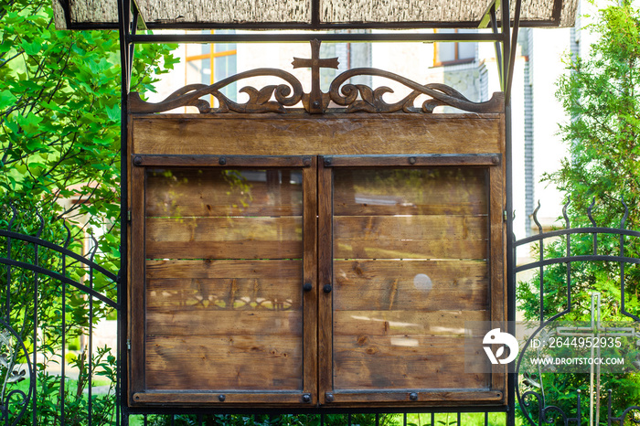 Church wooden empty notice board on street. Parish council outside memo board behind glass