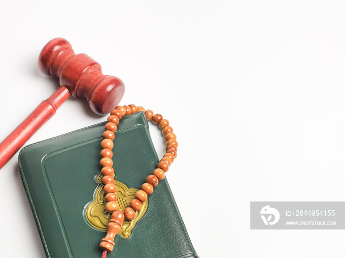 Top view image with noise effect tasbih or rosary beads with Holy Quran and gavel isolated on white background. Islamic law concept.