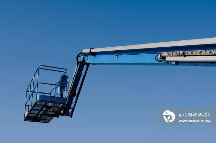 Telescopic boom lift raised up on blue sky background delivered to construction site ready to be used by steel frame erectors, roofers and painters