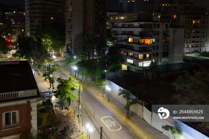 Empty roads at night view from top in Santiago city, Chile. Residential buildings and illuminated streets with trees. Quarantine, lockdown concepts