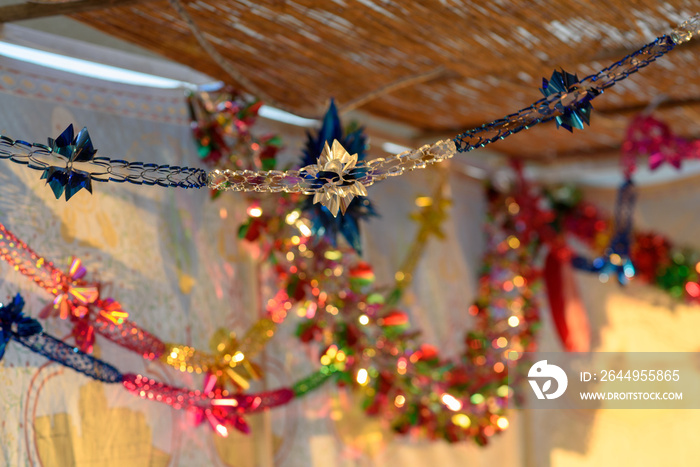 Colorful Sukkah decoration shiny garland at sunset light.