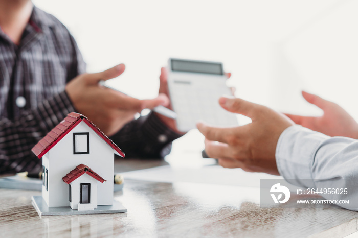 The real estate agent is explaining the house style to the clients who come to contact to see the house design and the purchase agreement.