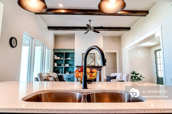 Close up of kitchen island of home with cozy living room view in the background