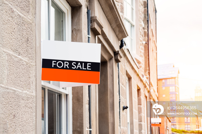 For sale sign outside a renovated aparment building in a city centre