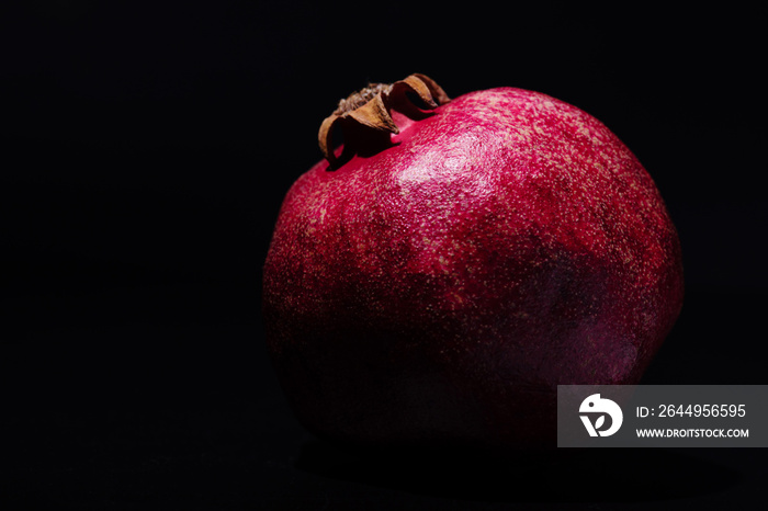 pomegranate on black background, close up photo