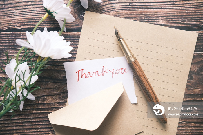 thank you message and envelope on wooden table