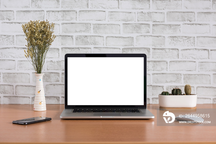 Blank screen of laptop computer with dry flowers, iPhone X and cactus vase on white bricks background