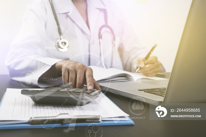 doctor working at office desk and calculator with computer.