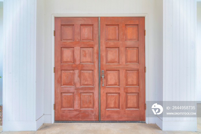 Wooden double doors against the white walls of a house at Carlsbad, San Diego, California