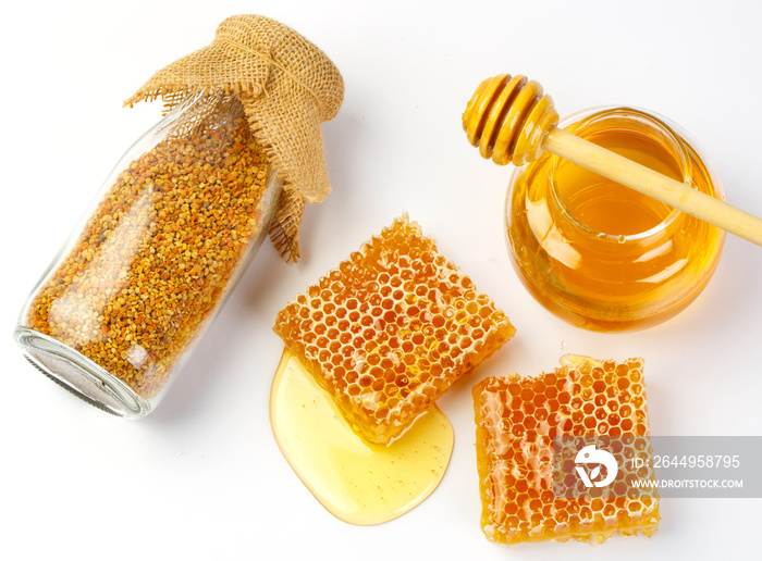 Honeycomb with jar and honey dipper isolated on white background