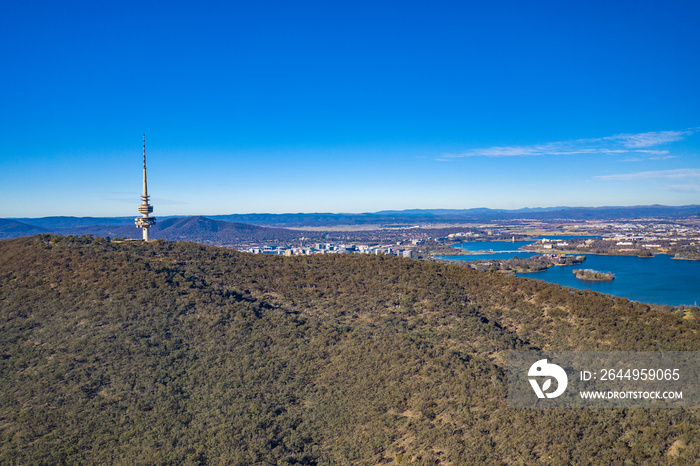 Aerial panoramic view looking past Telstra Tower toward Lake Burley Griffin in Canberra, the Capital of Australia on a sunny day