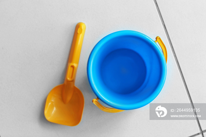 Children bucket and shovel on tile floor