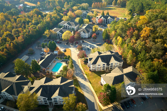 View from above of apartment residential condos between yellow fall trees in suburban area in South Carolina. American homes as example of real estate development in US suburbs